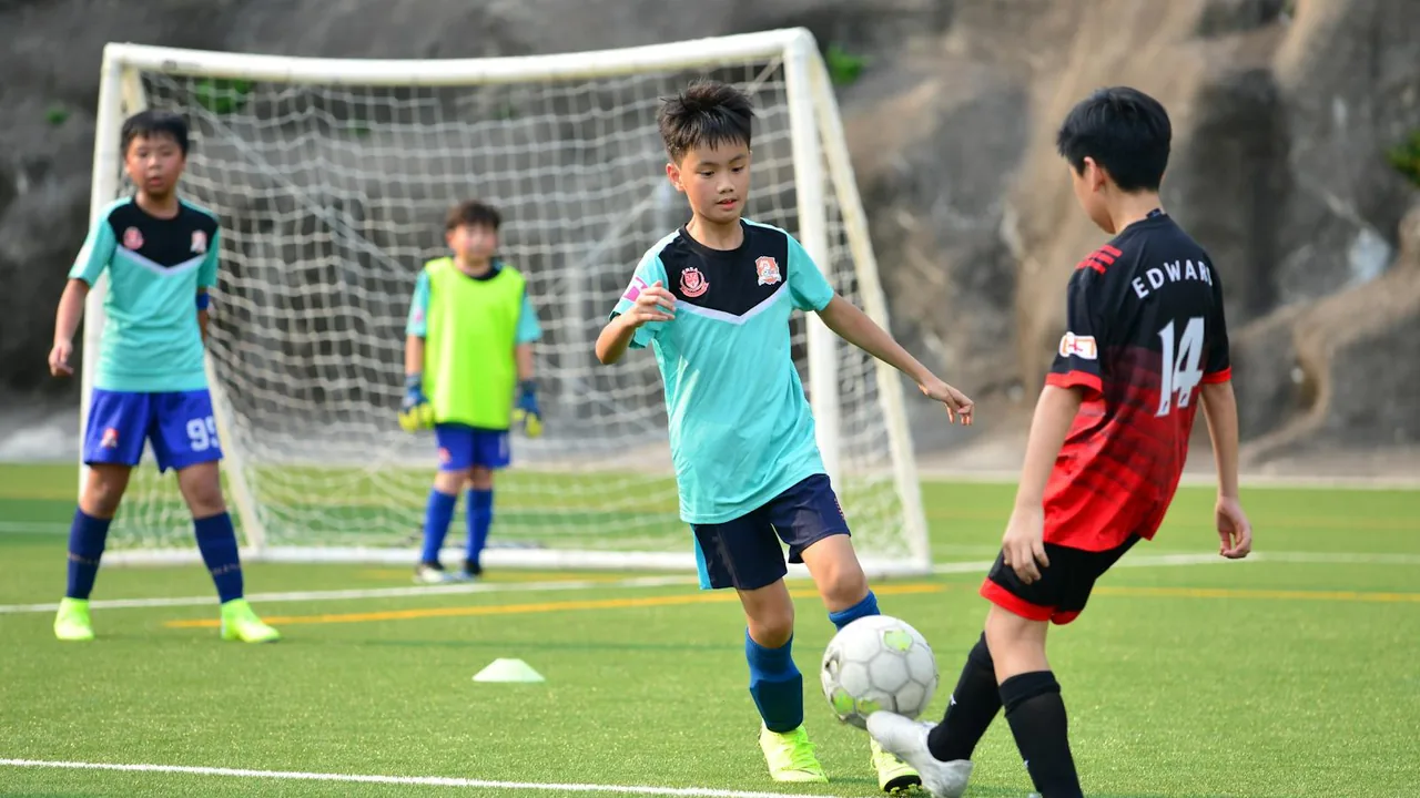 Enfants jouant au football en équipe lors d'une colonie de sport collectif