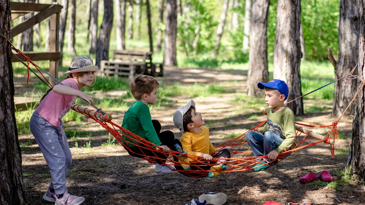 Enfants de dos marchant sur un sentier en pleine nature, lumière de fin d'après-midi
